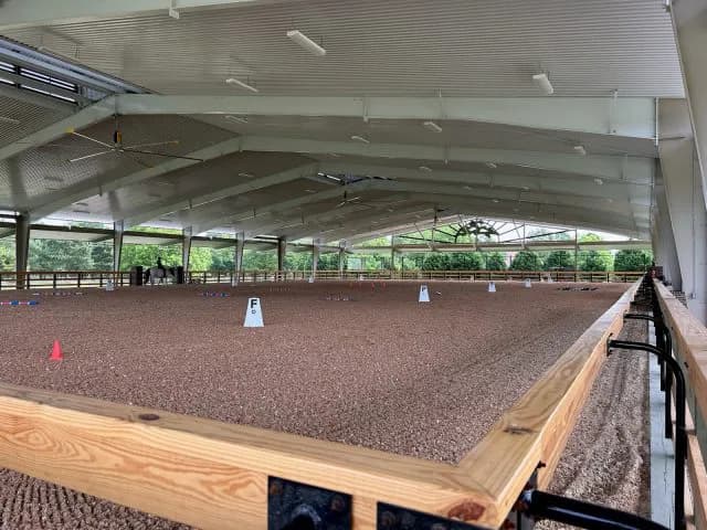 The inside of a coffee shop with white walls and bright teal stools at a counter