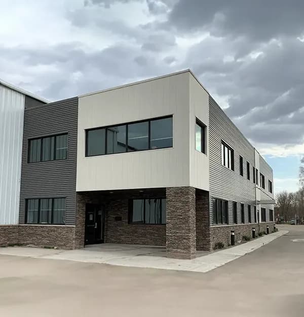 A tan and dark gray two story building with brown brick accents.