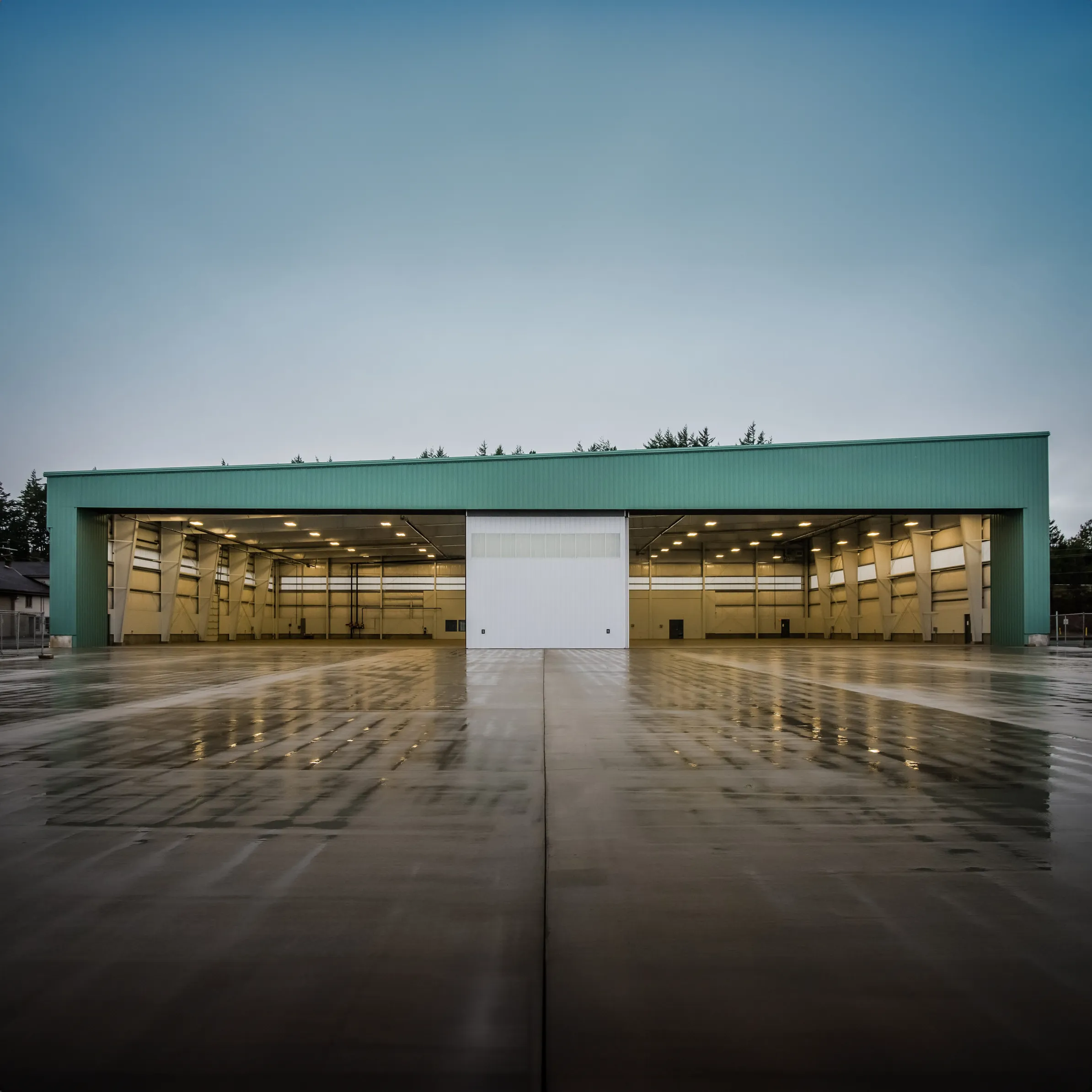 Green airplane hangar during the rain